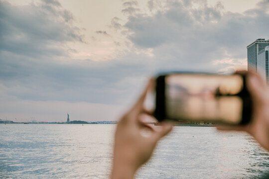 Phone taking picture of new york city skyline at sunset.