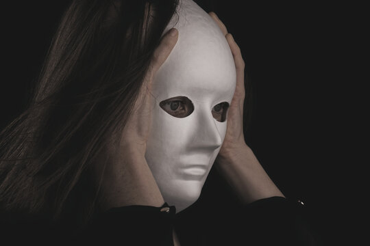 portrait of a woman in a white mask in the dark
