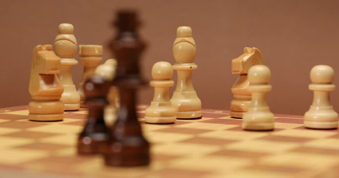 Board with chess pieces on color background, closeup