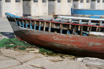 Fototapeta na wymiar Relitto di una vecchia barca sulla panchina del molo. Bari, sud Europa