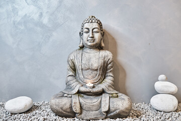 Grey buddha in a abstract physiotherapy chill out place with little stones