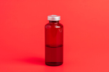 Macro Image Of Amber Vaccine Vial Set On Red Background