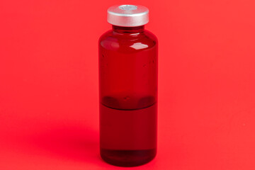 Macro Image Of Amber Vaccine Vial Set On Red Background