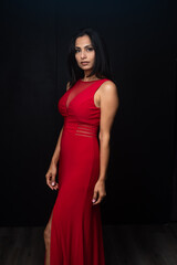 Fototapeta premium Studio images of beautiful Asian Indian woman wearing red dress on black background. 