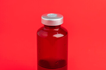 Macro Image Of Amber Vaccine Vial Set On Red Background