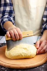 Woman baker prepares dough. Bread dough. Kneading the dough. Female hands stir the dough. Rustic style.