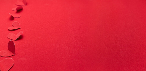 Obraz na płótnie Canvas Red paper hearts on a red background. Valentine's Day.