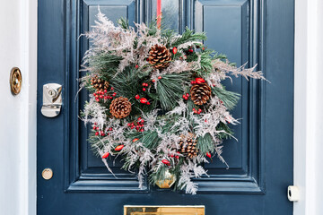 Closeup of a Christmas wreath hanging on a door at daylight