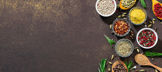 Long wide banner with assortment of spices and herbs on brown stone background. Template food blog social media. Spices market banner concept.
