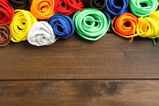 Colorful Shoelaces On Wooden Background, Flat Lay. Space For Text