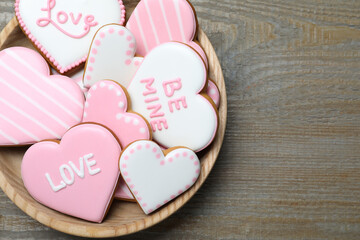 Naklejka na ściany i meble Valentine's day cookies in bowl on wooden table, top view. Space for text