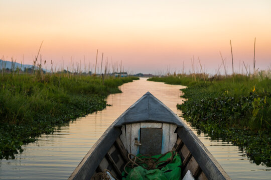 Motorboat on canal against sky during sunset, Lake Inle, Myanmar