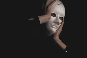 portrait of a woman in a white mask in the dark.