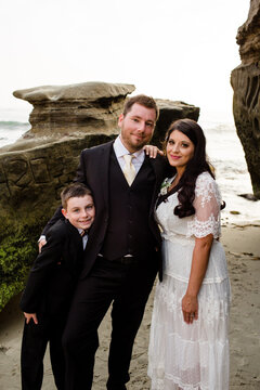 Newlyweds Posing with Nine Year Old Son on Beach in San Diego