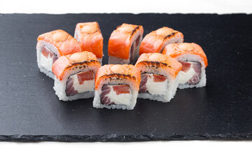 Traditional delicious fresh sushi roll on a black background with reflection. Sushi roll with rice, cream cheese, red fish, salmon. Sushi menu. Japanese cuisine, restaurant. Seafood, Asian cuisine.