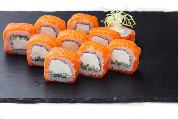 Traditional delicious fresh sushi roll set on a black background with reflection. Sushi roll with rice, cream chees, red fish, salmon. Sushi menu. Japanese kitchen, restaurant. Seafood, asian food