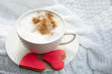 Valentine's day card. Breakfast. White cup  of hot coffee with milk and  red cookies  shaped  heart on white background.