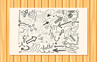 Different doodle strokes on a paper on wooden wall background