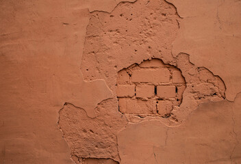 Old brown orange scratched shabby stucco wall and painted bricks element texture background