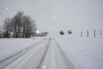 Fototapeta na wymiar Snow-covered road in winter in the countryside