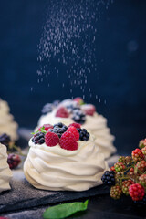 Homemade meringue basis for cake Pavlova with fresh blueberries and BlackBerry and powdered sugar...