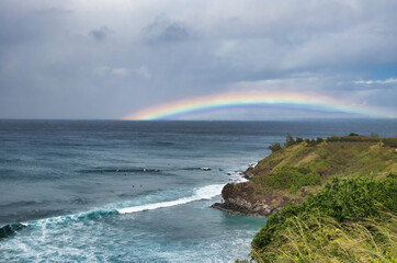 Low lying stretched out rainbow at Honolua Bay on Maui.