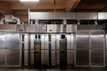 Modern bakery in confectionery factory. Industrial ovens for baking biscuits, cakes and cookies