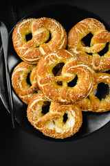 homemade pretzels with salt on black background