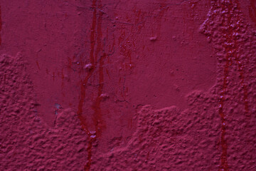 Cement wall with red paint and water streams - close up outdoors. Texture, material, surface.