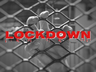 Selective focus monochrome image with noise effect human hand on fence with text LOCK DOWN.