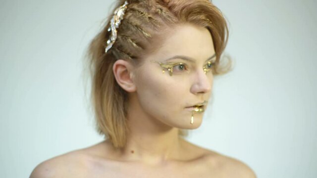 Golden girl. Gold makeup. Fashion art skin Woman face portrait closeup.