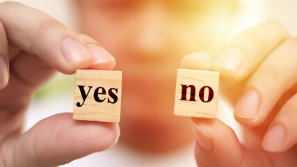 Yes or no, man holding two wooden cubes with yes or no written on it, making decision