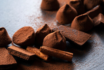 Cocoa powder, truffle chocolate and cinnamon on a stone plate