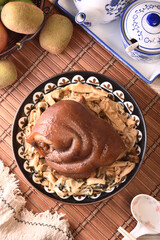 Stewed pork trotters with bamboo shoots in brown sauce on the plate 