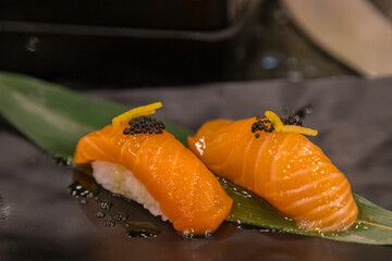 Salmon sushi placed on bamboo leaves