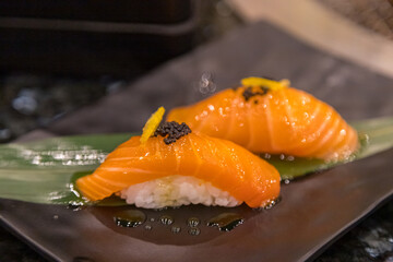 Salmon sushi placed on bamboo leaves