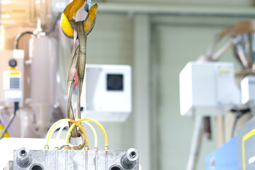 Hook for industrial heavy lifting equipment in the factory on the background of the machine.