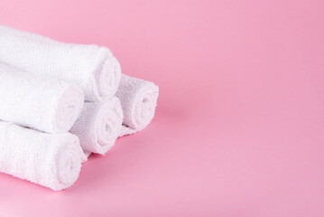 White spa towels pile on pink background