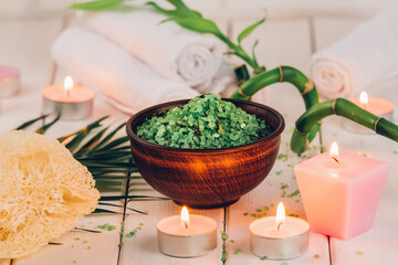 Obraz na płótnie Canvas Spa. Green herbal spirulina salt in ceramic bowl, spa towels, pink scented candle and bamboo. Toned, matte