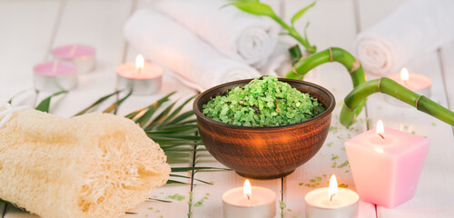Spa. Green herbal spirulina salt in ceramic bowl, spa towels, pink scented candle and bamboo. Toned, matte