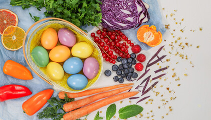 easter eggs in basket.

Easter eggs in a basket with vegetables, fruits and berries around on a pink background, close-up top view.