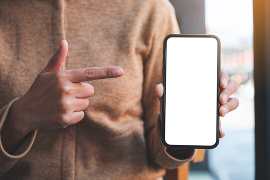 Mockup image of a woman pointing finger at a mobile phone with blank white screen