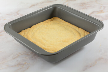 Baked pastry dough in bottom of baking pan for making dessert bars