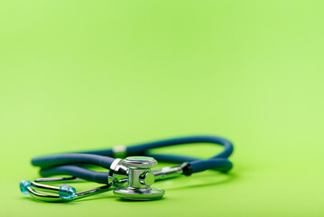 Selective focus of blue stethoscope on green background. For check heart or health check up concept. Copy space..