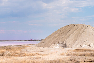 People gathering salt of pink salty Siwash Lake, colored by microalgae, famous for antioxidant properties, enriching water by beta-carotene at sunset