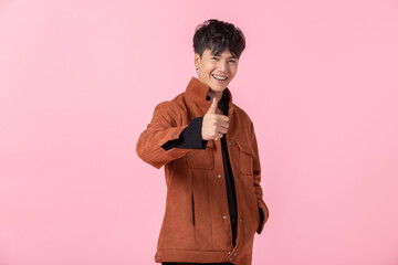 Asian a man handsome young pointing with hands show showing thumbs up to the side eyes looking at camera in love isolated on pink blank copy space studio background.