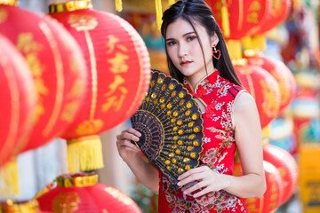 Asian woman wearing red traditional Chinese cheongsam decoration with paper lanterns with the...