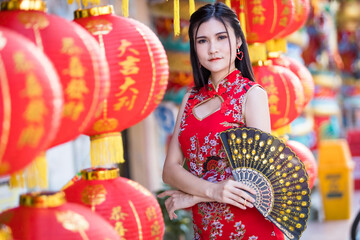 Asian woman wearing red traditional Chinese cheongsam decoration with paper lanterns with the...
