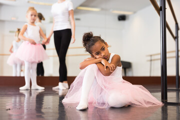 Portrait of sad and tired little ballerina in choreography hall © JackF