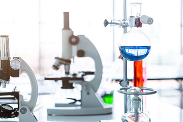Microscope and test tubes with lab glassware in laboratory background, research and Scientific concept